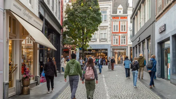 People walking on cobblestone street between old buildingsin Maastricht, Netherlands.