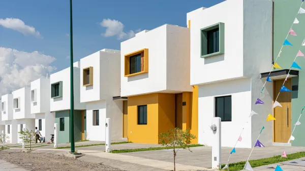 Two-story white boxy new homes in Guadalajara with green and yellow accent walls.