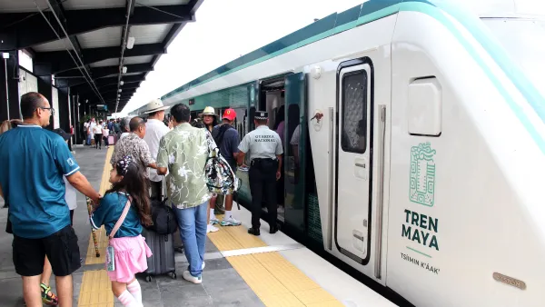 Passengers boarding a white Tren Maya train in Merida, Yucatan, Mexico.