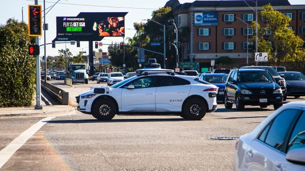 A white Waymo SUV self-driving robotaxi in an intersection in Los Angeles, California.
