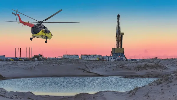 An oil and gas field in the Arctic with a helicopter flying overhead.
