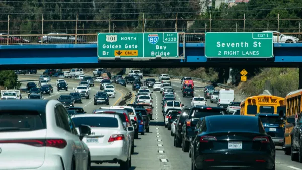 Busy freeway in Northern California with green signs for Golden Gate and Bay Bridges.