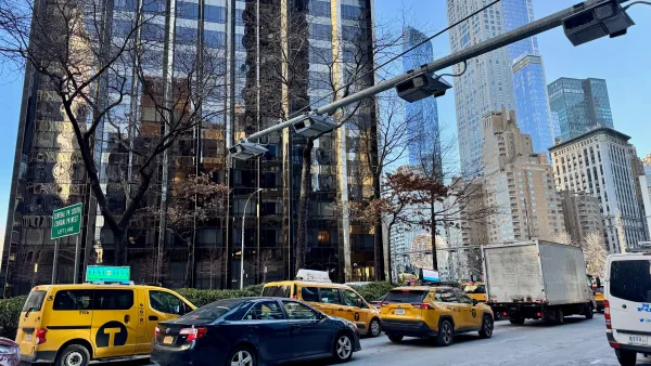 Cars driving under automatic congestion pricing toll machines on Broadway next to the Trump International Hotel in Manhattan, New York City.