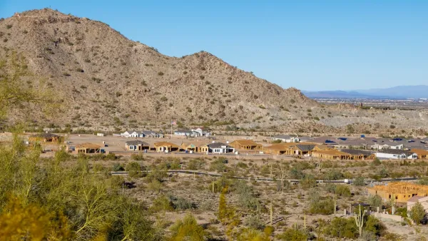 Aerial of houses under construction in Buckeye, Arizona against desert mountains.