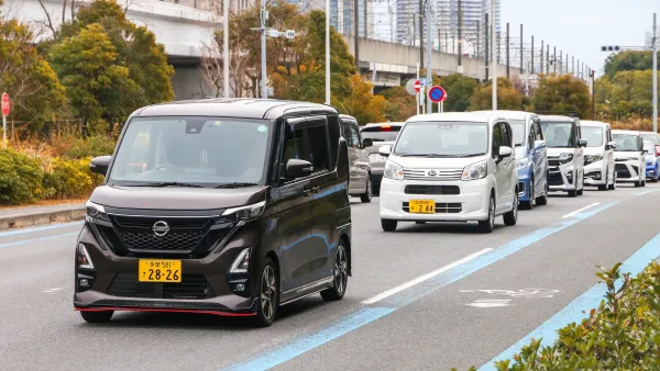 Row of tiny Japanese kei cars on street in Tokyo.