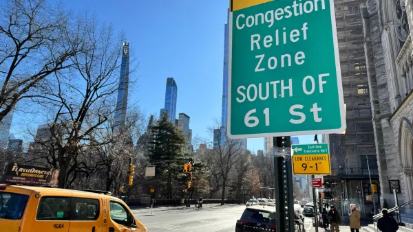 Close-up of green congestion relief zone sign in New York City with yellow cab van on street in background.