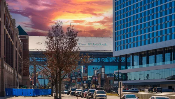 Wide street in downtown Arlington, Texas with colorful sunset.