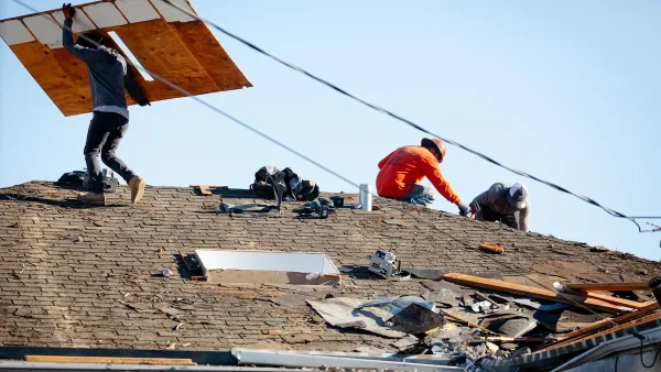 construction workers on the roof of a house.