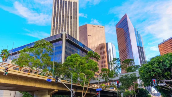 Striking view of Los Angeles financial skyline featuring the World Trade Center and nearby buildings, showcasing urban design against a bright sky.