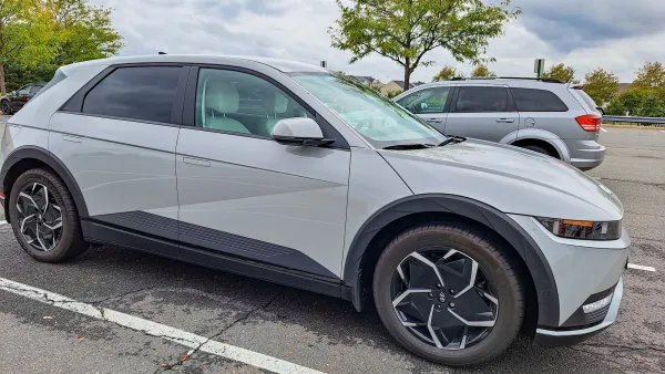 Grey electric SUV parked in parking lot.