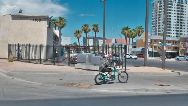 Person on bike rides onto sidewalk on curb cut in Las Vegas, Nevada.