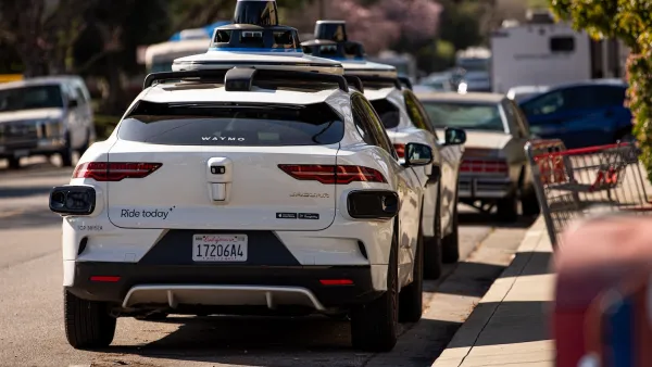 Two white Waymo self-driving cars parked nect to curb in Mountain View, California.