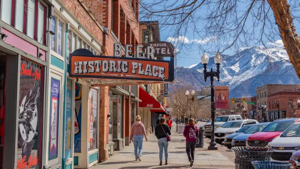 Historic downtown of this Utah city with quaint brick buildings and scenic snow-capped mountains in background.