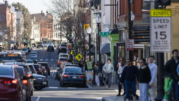 Pedestrians and cars on busy Washington D.C. street and sidewalk.
