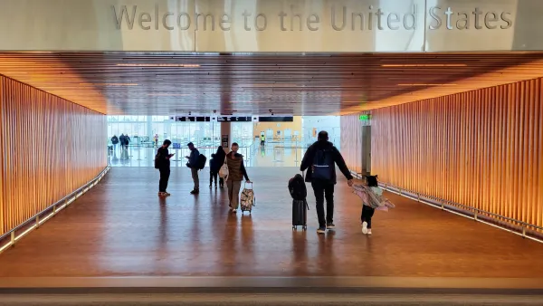 "Welcome to the United States" sign over wide corridor at U.S. airport.