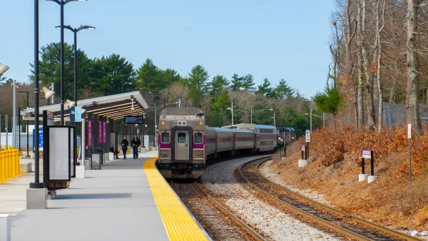 Outdoor train platform in Middleboro MA with MBTA train pulling in.