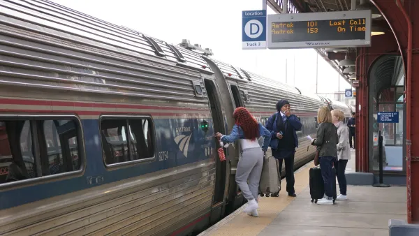 Passengers boarding an Amtrak train at an outdoor platform in Wilmington, Delaware.