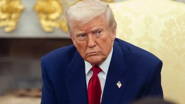 Trump in a navy suit frowns at the camera.