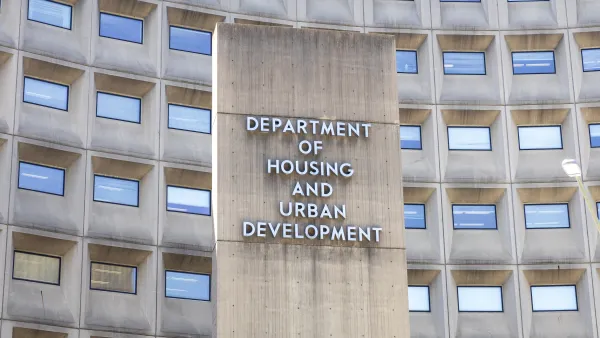The Department of Housing and Urban Development Building sign. The cement sign is flanked on either side by rows of windows.