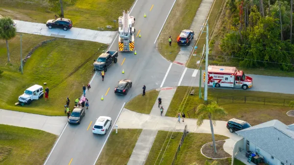 Aerial of traffic crash at intersection with ambulance and first responders on scene.