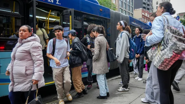 People boarding and deboarding blue NYC bus.