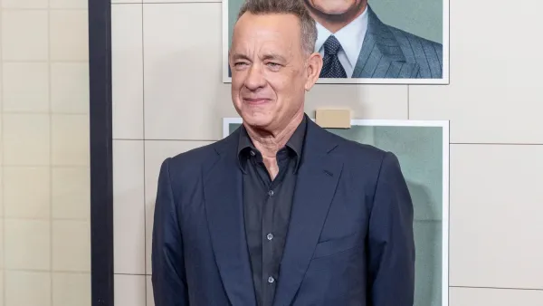 Tom hanks stands in front of film posters at premiere of The Phoenician Scheme in New York CIty.
