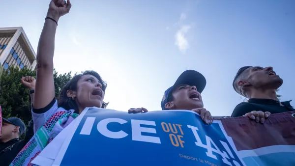 Protesters holding a blue "ICE out of LA" sign with LA Dodgers logo in Los Angeles.