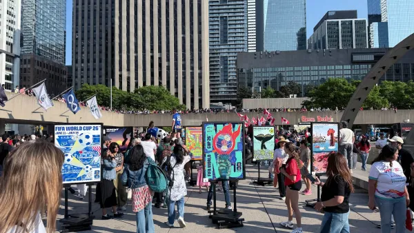 Soccer fans walk around World Cup countdown event in plaza in downtown Toronto, Canada.