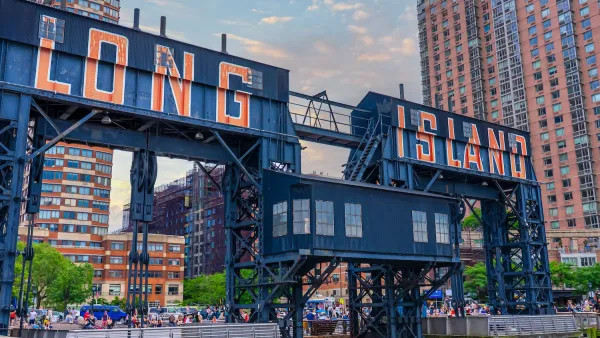 Red 'Long Island' text on blue steel bridge/gates over river.