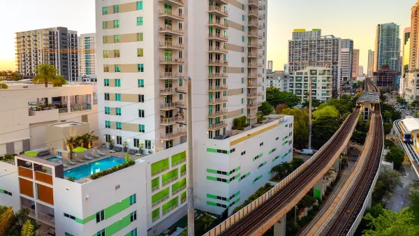High-rise apartment buildings next to elevated rail line in dense urban neighborhood in Miami, Florida.