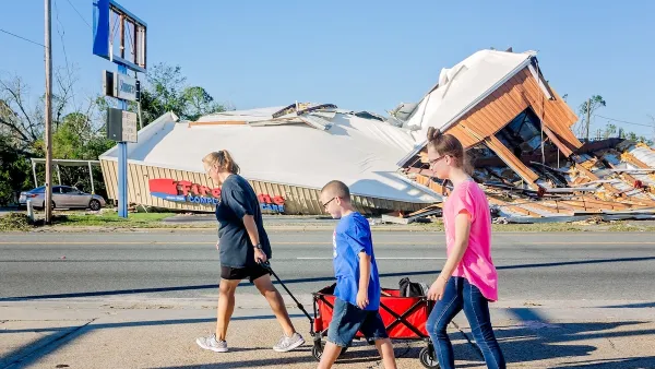 A Florida family with their belongings in a wagon walks past a destroyed storm after a hurricane. 