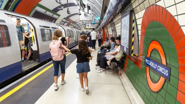 Passengers walk through a London Tube tunnel