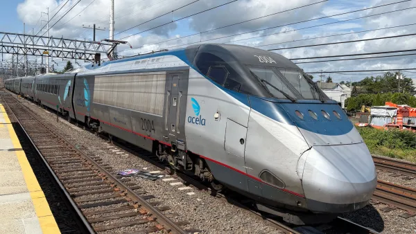 Silver Amtrak Acela train on track.