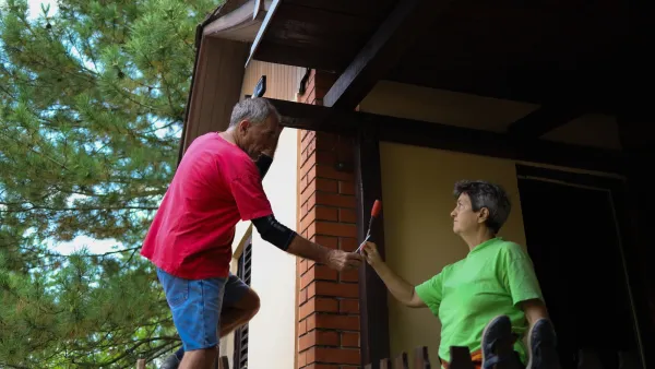 Older couple working on the exterior of their home.