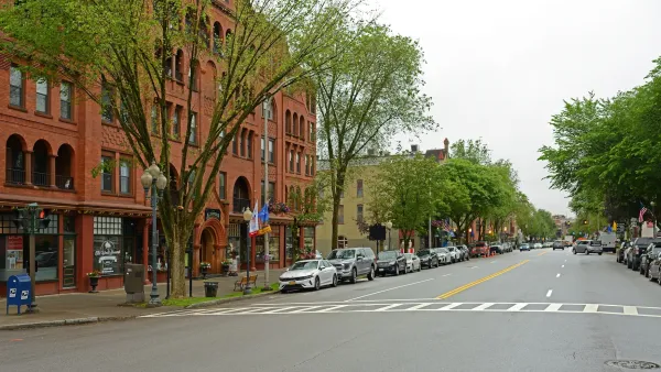 Wide main street with five-story red brick building on left in downtown Saratoga Springs, Florida.