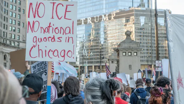 Crowd of protesters with white sign with red lettering reading "No ICE No National Guard in Chicago."