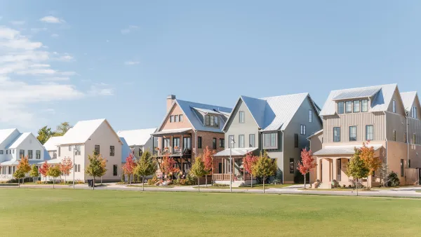 Row of modern two-story homes with large grass lawn in front against pale blue sky in Oklahoma City, Oklahoma.
