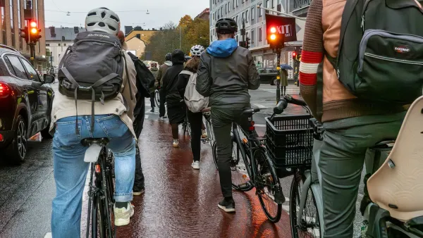 Group of people on bikes stopped at red light on street in Stockholm, Sweden.