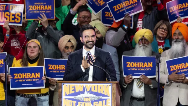 Mayoral candidate Zohran Mamdani speaks during 'New York is not for sale' rally at Forest Hill Stadium in New York. A diverse crowd behind him holds his campaign signs.