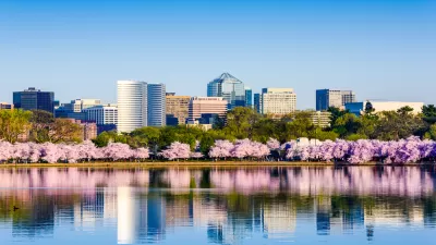 View across lake of Washington, D.C. office buildings with blooming cherry trees in front on lakeshore