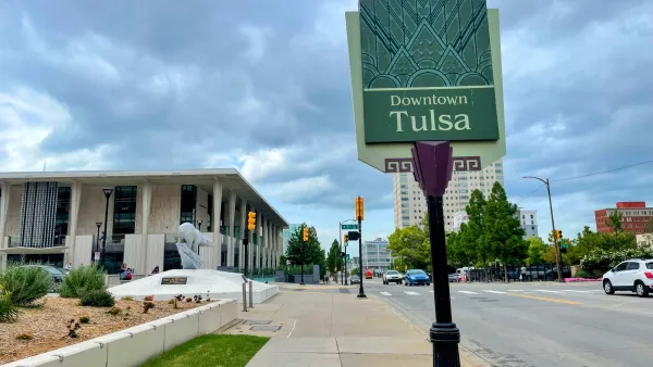 Downtown Tulsa sign and street view with the Tulsa Performing Arts Center under stormy skies.