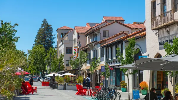 Street with outdoor seating and bike racks next to Spanish Revival-style buildings in Palo Alto, California.