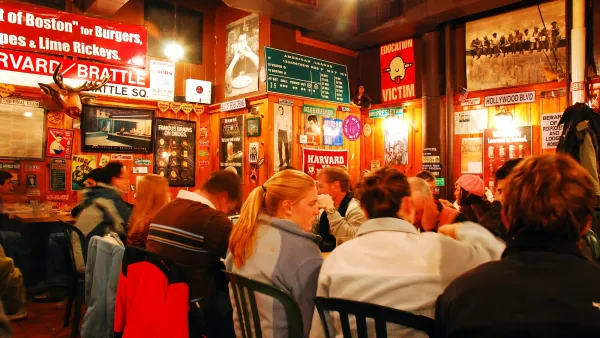 Cozy family-style restaurant with large group of people sitting at long table.