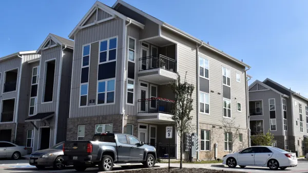 Large three-story apartment building surrounded by parking in Houston, Texas.