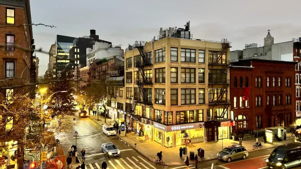 Looking down on street scene with people walking at dusk on vibrant East Village street, New York City.