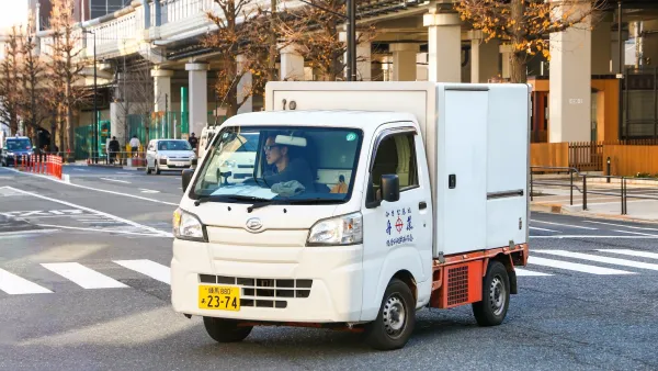 Small white kei truck on street in Tokyo, Japan.