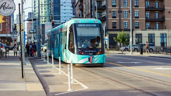 Teal Kansas City streetcar on downtown street.