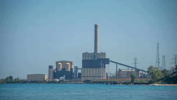The J.H. Campbell Generating Plant, a concrete building in front of a large body of water.