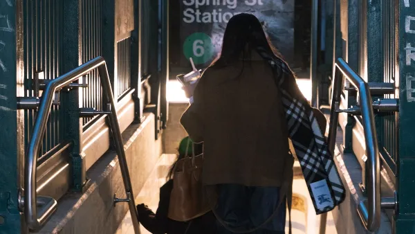 A woman descends into Spring Street station in NYC.