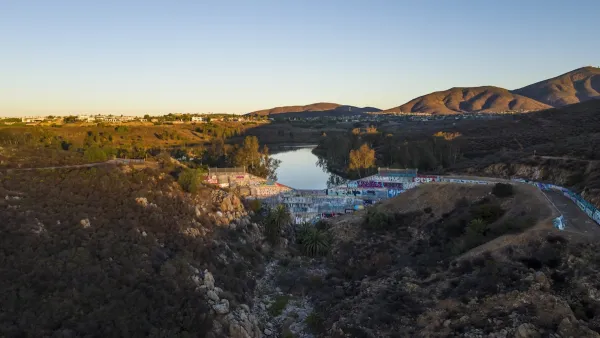 Drone photo of dam on upper Otay Lakes Reservoir. It is covered in graffiti. 